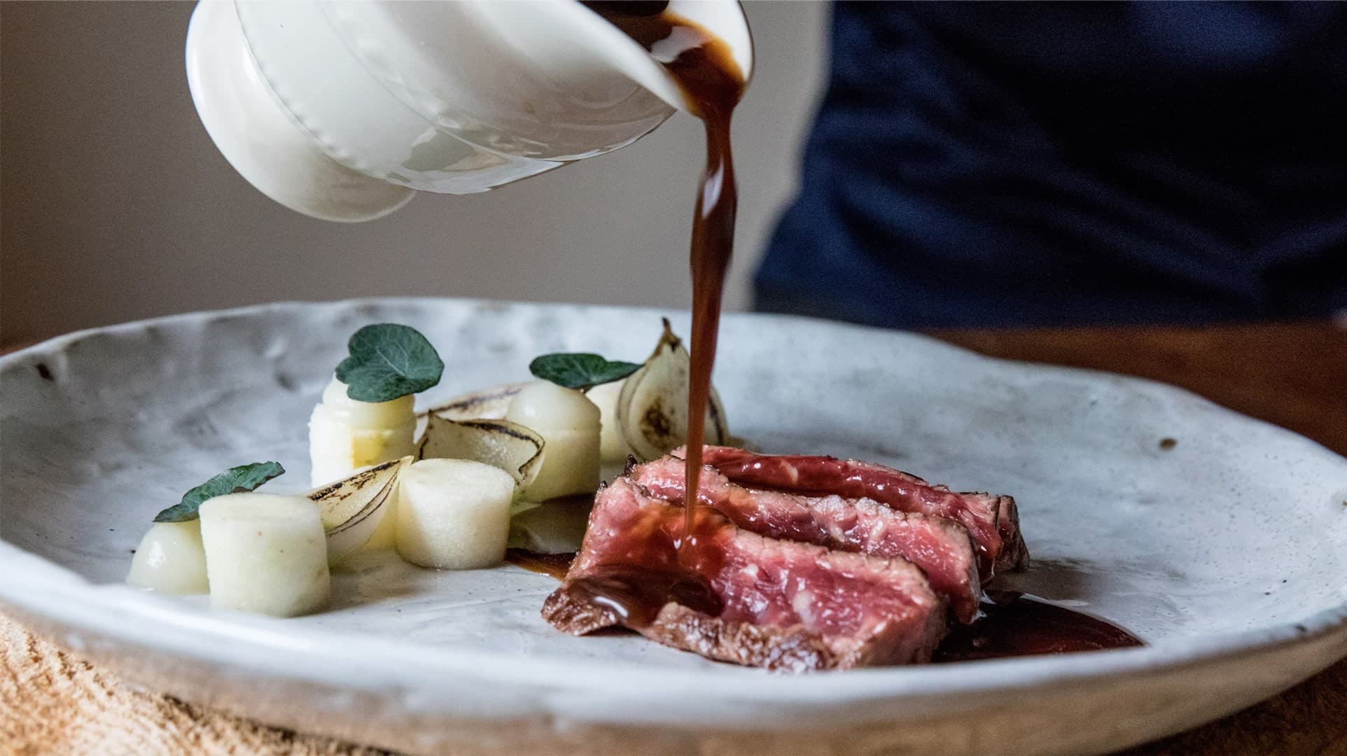 Foto van gerecht met biefstuk en jus